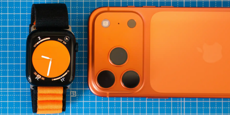 Minimalist setup featuring an orange-themed smartphone and smartwatch on a blue grid background