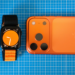 Minimalist setup featuring an orange-themed smartphone and smartwatch on a blue grid background