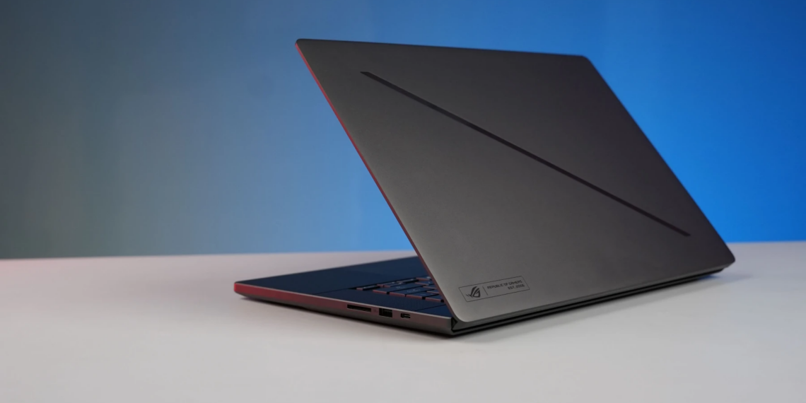 Elegant black laptop on a minimalist desk with a gradient blue background, perfect for tech and work concepts.