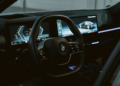 Close-up view of a BMW interior featuring a steering wheel and modern dashboard screens in Erbil