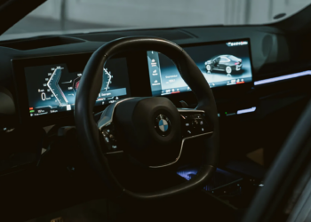 Close-up view of a BMW interior featuring a steering wheel and modern dashboard screens in Erbil