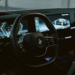 Close-up view of a BMW interior featuring a steering wheel and modern dashboard screens in Erbil