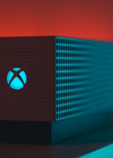 Close-up of an illuminated gaming console with a red and blue light aura