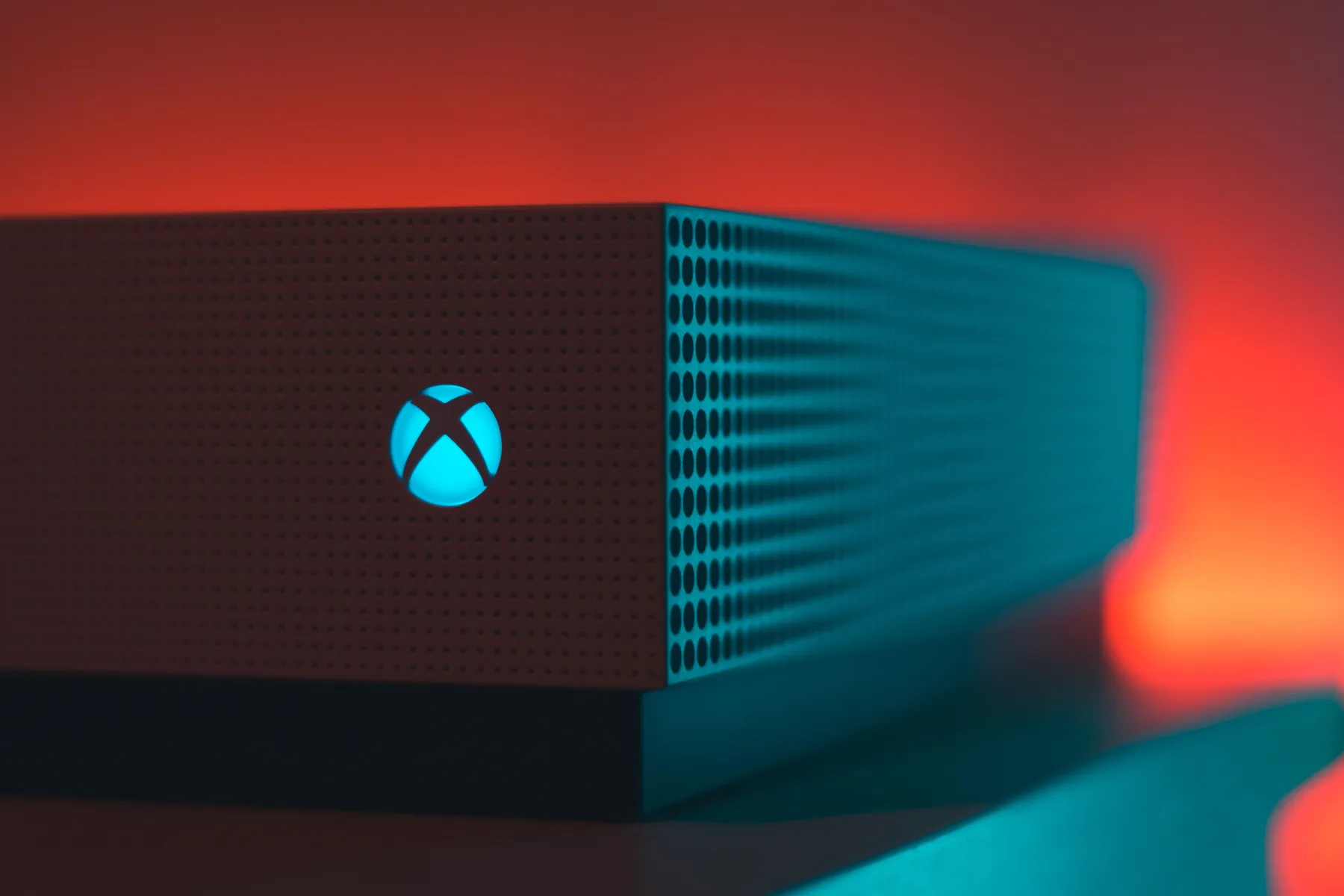 Close-up of an illuminated gaming console with a red and blue light aura