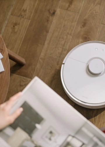 A sleek robot vacuum cleaner operating on a wooden floor, symbolizing modern home technology