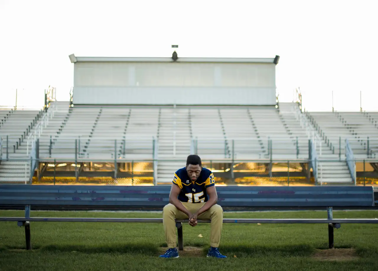male athlete sitting alone on the bench