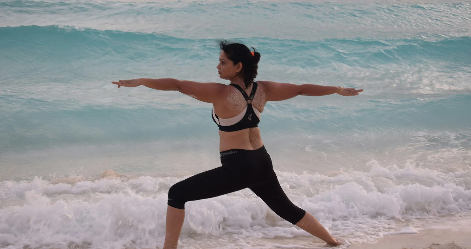 a woman do yoga at the beach