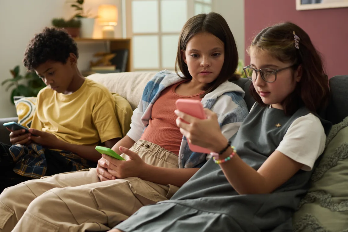 children engaging with smartphones on cozy